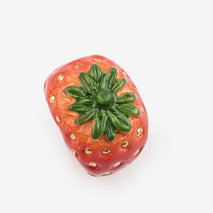 Anillo frutilla de porcelana sobre fondo neutro — Leontina Joyas